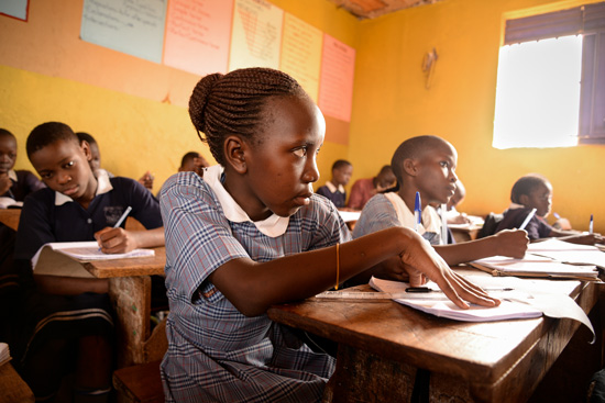 Young girl listening and taking notes in school