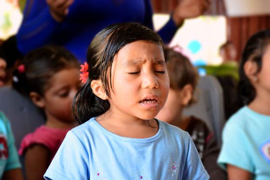 Young girl praying and worshiping in church