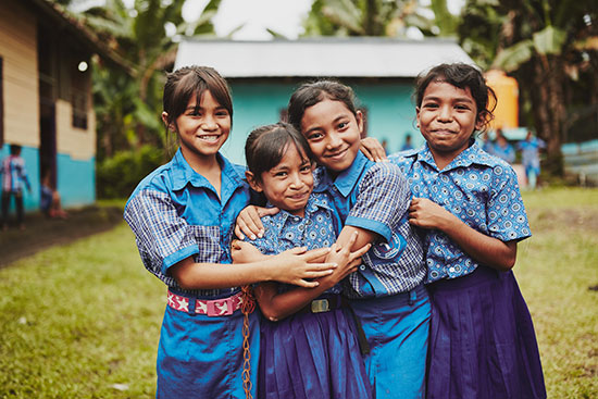 Young girls in school uniforms smiling